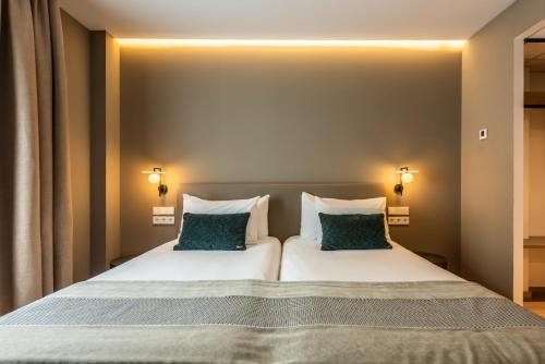 a bedroom with a large bed with two pillows at Silken Puerta de Irati in Ochagavía