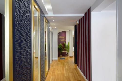 a hallway with wood flooring and a hallway with doors at Hôtel Le Montmartre Saint Pierre in Paris