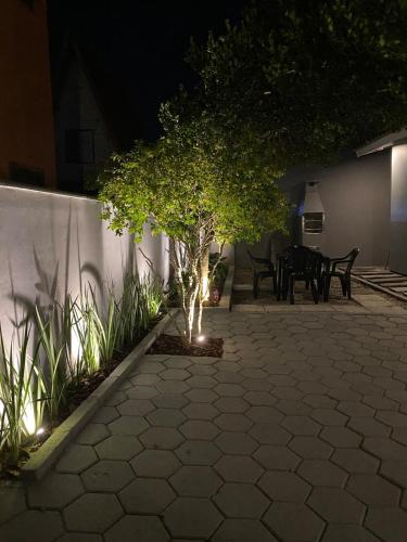 a patio at night with a tree and a table at Casa Refúgio in Florianópolis