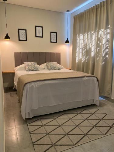 a bedroom with a large bed and a window at Casa Refúgio in Florianópolis