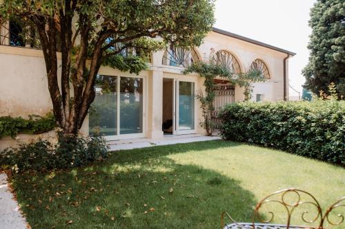 a house with a yard with a tree at Wine Relais Villa Cipolla Pieropan in Tregnago