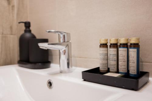 - un lavabo dans la salle de bains avec 4 bouteilles de produits capillaires dans l'établissement 