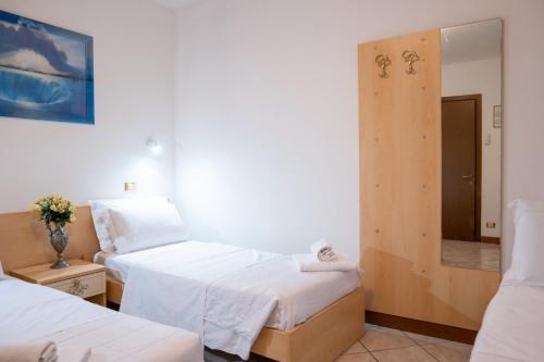 a hotel room with two beds and a mirror at Hotel New Aurora Venice in Marghera