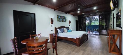 a bedroom with a bed and a table and a desk at Cabañas Refugio Verde Monteverde in Monteverde Costa Rica