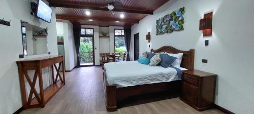 a bedroom with a bed and a television in it at Cabañas Refugio Verde Monteverde in Monteverde Costa Rica
