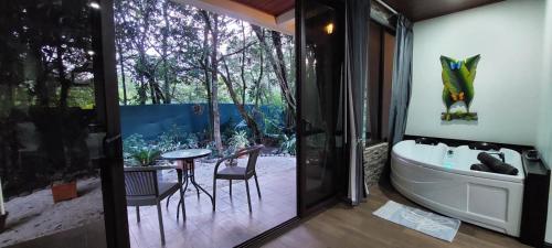 a bathroom with a tub and a table and chairs at Cabañas Refugio Verde Monteverde in Monteverde Costa Rica