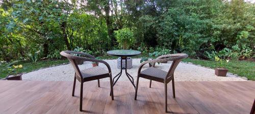 two chairs and a glass table on a wooden deck at Cabañas Refugio Verde Monteverde in Monteverde Costa Rica