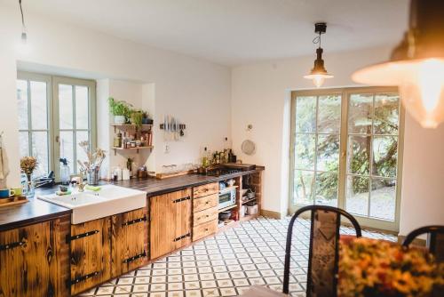 a large kitchen with wooden cabinets and a sink at Jedinečné bývanie v blízkosti Banskej Štiavnice in Banský Studenec