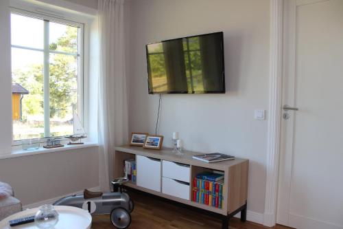 a living room with a tv on the wall at Villa Vita Pärla in Timmernabben