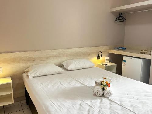 a bedroom with a white bed with two stuffed animals on it at Europa Hotel Brasília by Bsb Inn in Taguatinga