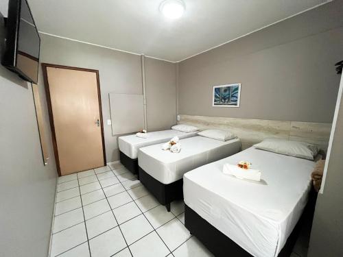 a hotel room with two beds and a mirror at Europa Hotel Brasília by Bsb Inn in Taguatinga