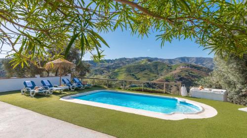 a swimming pool in a yard with chairs and trees at Los Olivos de Jaure El Borge by Ruralidays in Borge