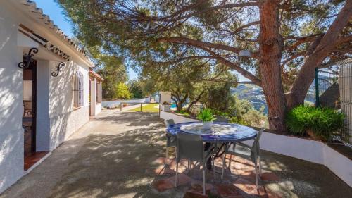 a table and chairs on a patio with a tree at Los Olivos de Jaure El Borge by Ruralidays in Borge