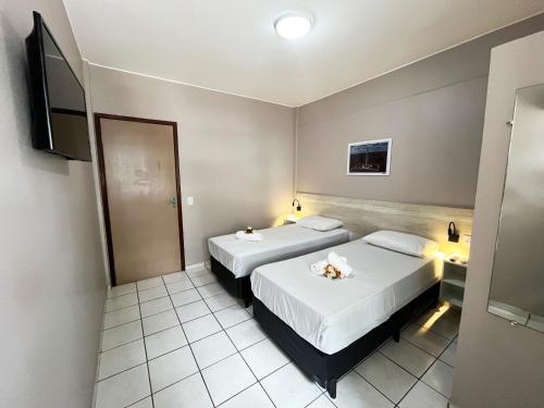 a hotel room with two beds and a television at Europa Hotel Brasília by Bsb Inn in Taguatinga
