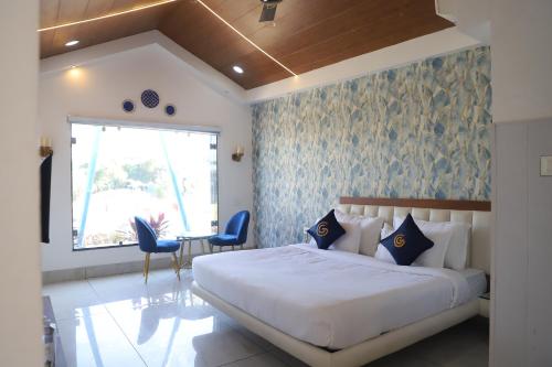 a bedroom with a bed and a table and chairs at Cosmos Resort Maliblu in Indore