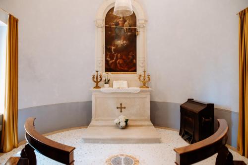a church with a cross and a altar with chairs at Wine Relais Villa Cipolla Pieropan in Tregnago