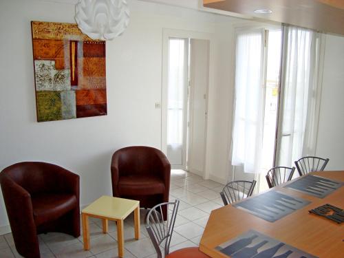 une salle à manger avec des chaises et une table et une table et une tableweredktop dans l'établissement APPARTEMENT FACE MER T2 35 m2 pour 4 personnes proche tous commerces, à Saint-Jean-de-Monts