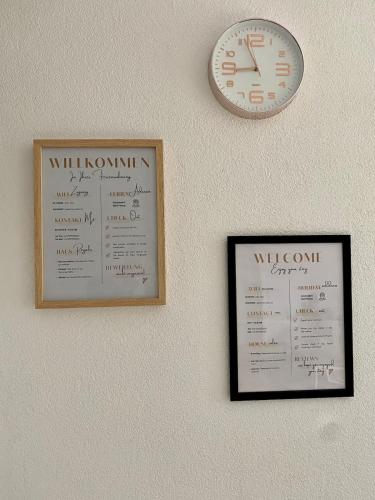 two certificates and a clock on a wall at Apartment Katz in Berghausen