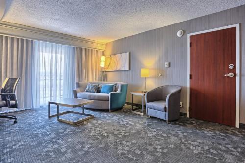 a hotel room with a couch and a chair at Courtyard by Marriott Harrisburg West/Mechanicsburg in Mechanicsburg