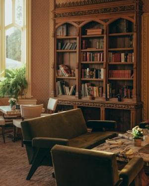 a living room with a book shelf filled with books at Oakley Court in Windsor