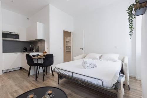 une chambre blanche avec un lit et une cuisine dans l'établissement 