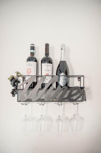 a wine rack with four wine bottles and wine glasses at Casa Giulietta Junior20 with private parking in Blevio