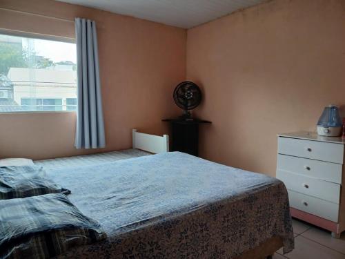 a bedroom with a bed and a window and a dresser at Apartmento ótima localização ! in Garanhuns