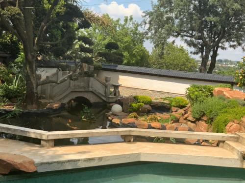 a garden with a pond and a water feature at Oasis On Lily with OWN Pool in Johannesburg