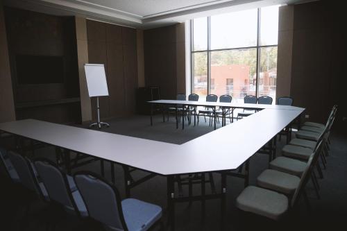 a conference room with tables and chairs and a large window at Azalaï Hôtel Ouagadougou in Ouagadougou