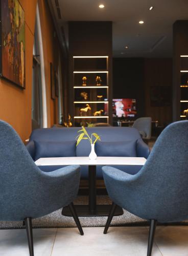a waiting room with two chairs and a table with a vase at Azalaï Hôtel Ouagadougou in Ouagadougou