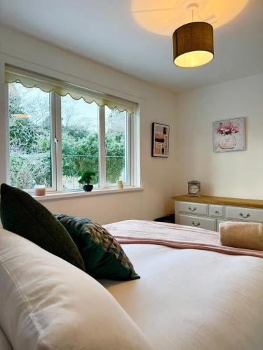 a bedroom with two beds and a window at King's Cottage in Tassagh
