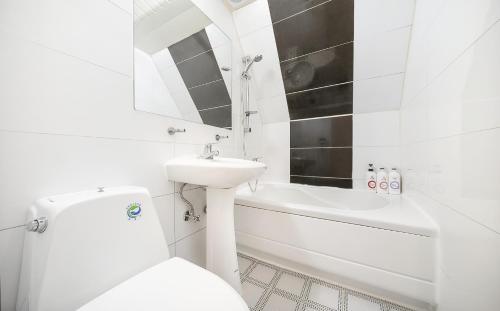 a white bathroom with a sink and a toilet at Hotel Castle in Gwangmyeong