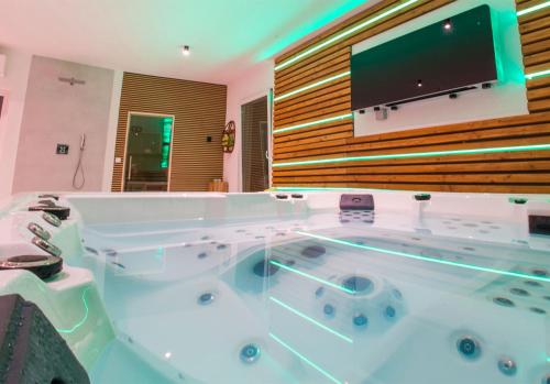 a large bathroom with a tub with a tv on the wall at Villa Anto in Pridraga