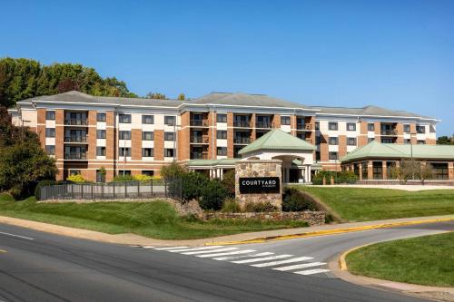a large building with a sign in front of a street at Courtyard by Marriott Newark-University of Delaware in Newark