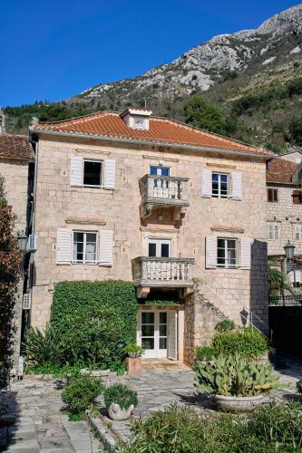 a large brick building with a balcony on it at Waterfront Historical Villa Perast in Perast