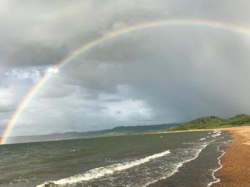 a rainbow over a beach with the ocean at Kite Bungalow Bahia Salinas in La Cruz