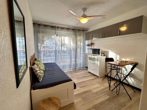 Ce petit appartement comprend une cuisine et une table dans une pièce. dans l'établissement AStudio Lumineux à la plage, situation idéale commerces, bateaux ,restaurant à 20 m , Plage à 50 m, idéal pour un séjour reposant, à Mauguio