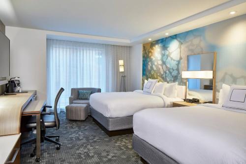 a hotel room with two beds and a desk at Courtyard Baltimore Downtown/McHenry Row in Baltimore