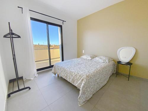 une chambre avec un lit et une grande fenêtre dans l'établissement Villa avec piscine, à Montblanc