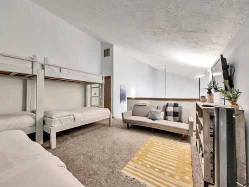 a bedroom with two bunk beds and a couch at Giant Steps 58 Ski in out in Brian Head