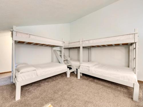 two bunk beds in a room with a ladder at Giant Steps 58 Ski in out in Brian Head