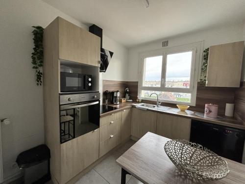 Il comprend une cuisine équipée d'un four micro-ondes et d'une table. dans l'établissement Le Podium - 9pers - Circuit Bugatti - Rêve au Mans, au Mans