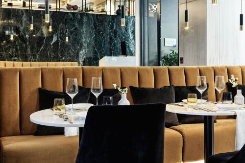 a dining room with two tables with wine glasses at Academias Hotel, Autograph Collection in Athens