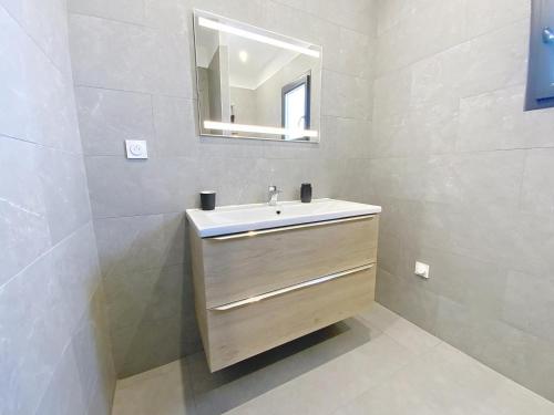 une salle de bain avec un lavabo et un miroir dans l'établissement Villa avec piscine, à Montblanc