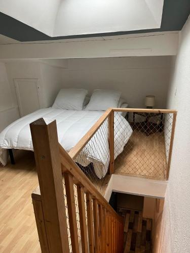 Ce lit se trouve dans une petite chambre avec un escalier. dans l'établissement Logement calme proche du Touquet, à Cucq