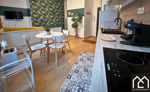 une cuisine et une salle à manger avec une table et des chaises dans l'établissement Le Nid des Tintelleries - Parking QPARK Gratuit, à Boulogne-sur-Mer