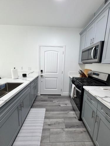 a kitchen with white cabinets and a stove top oven at Cozy Tiny House Near The Beach in Guadalupe