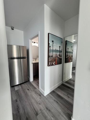 a hallway with a refrigerator and two pictures on the wall at Cozy Tiny House Near The Beach in Guadalupe