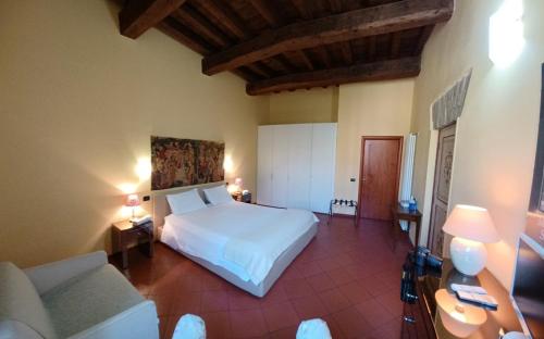 a bedroom with a white bed and a couch at CASA DUCHESSE al Castello in Ferrara