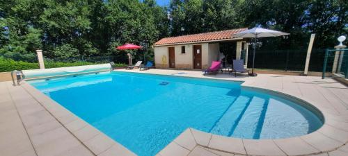 une grande piscine bleue dans une cour dans l'établissement Au Bonheur d'Angeline, à Castelnaud-la-Chapelle